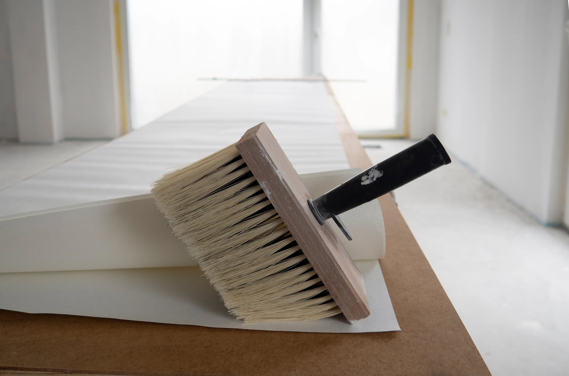 Intérieur lumineux avec pinceau de badigeon professionnel posé sur échantillons de peinture et nuanciers