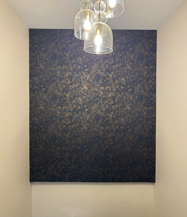 Intérieur d'un couloir avec un mur d'accent recouvert d'un papier peint intissé motif floral, coloris bleu nuit et or bronze