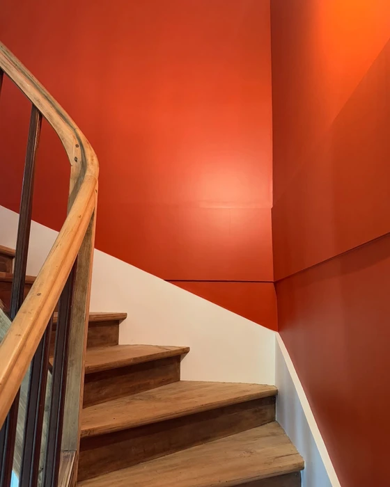 Artisan à genoux posant un parquet flottant, ajustant une lame de stratifié effet chêne doré