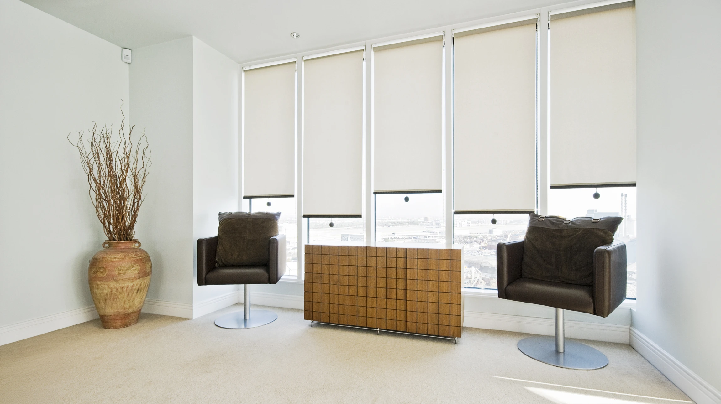 Gros plan d'une moquette de couleur chaleureuse (beige, gris ou taupe) fraîchement posée dans un intérieur résidentiel lumineux. La photo montre le détail de la texture douce de la moquette, avec en arrière-plan flou un intérieur moderne et épuré, permettant aux clients de visualiser le confort et la douceur du revêtement une fois installé dans leur habitat.