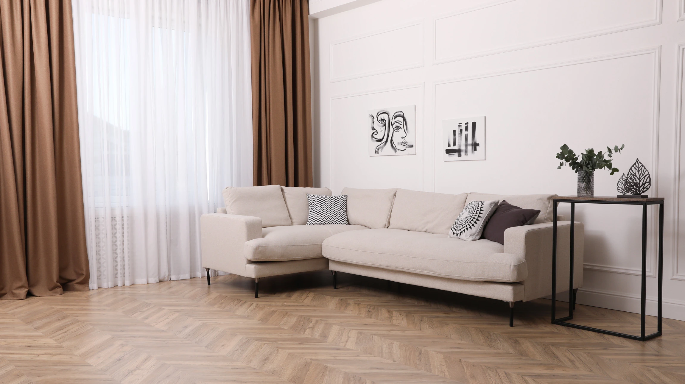 Ouvrier installant du parquet en bois clair dans un intérieur résidentiel, main positionnée sur une lame pour ajustement précis